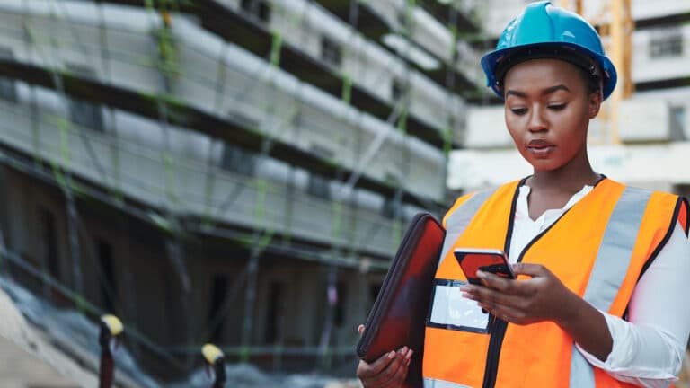 Woman using a smartphone while working at a construction site